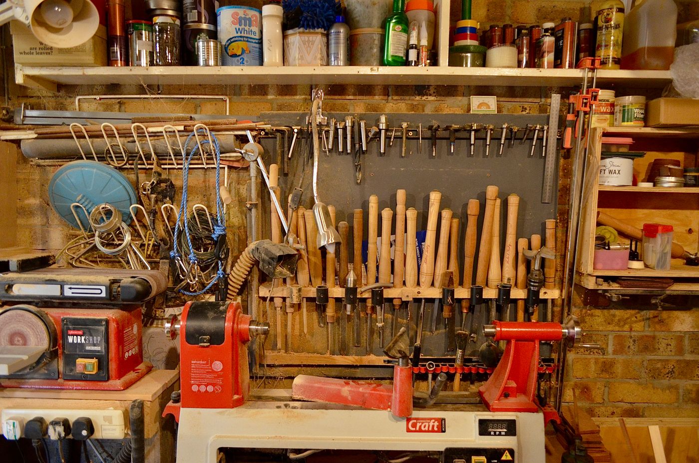 Well-organized woodworking workshop with tools, equipment, and workbenches neatly arranged