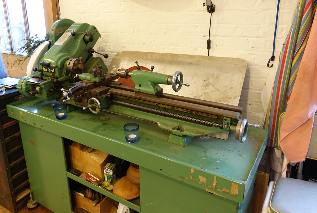 A woodturning workshop with a lathe and benches