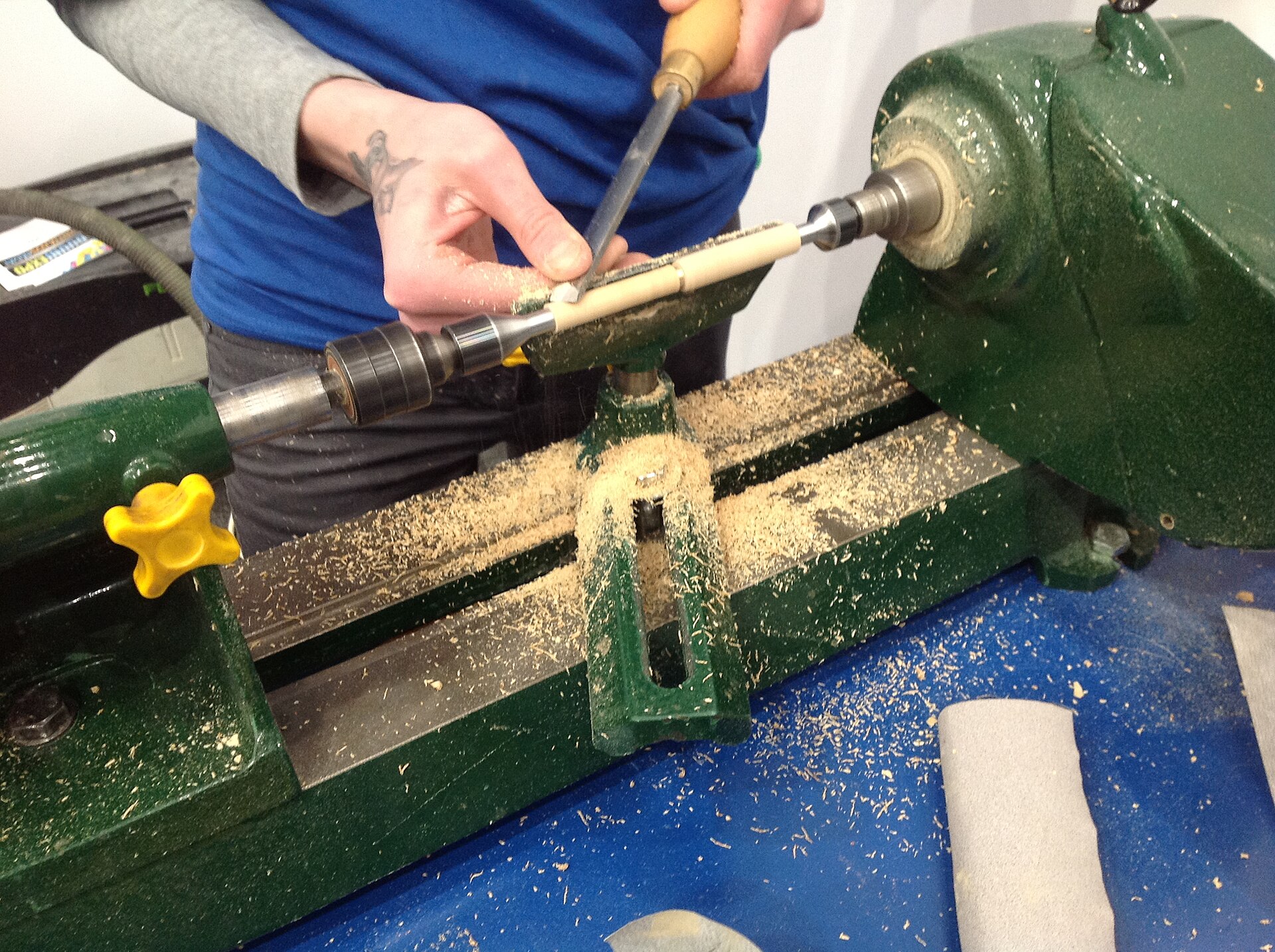 A woodturner cutting a spinning workpiece