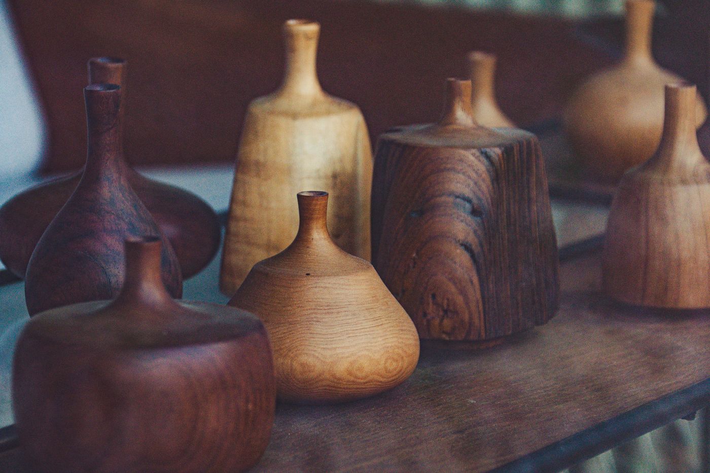 Assorted handmade turned wooden vases and vessels displayed on a workshop surface